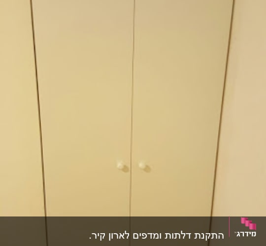ארון עץ לבן עם שתי דלתות וידיות עגולות
